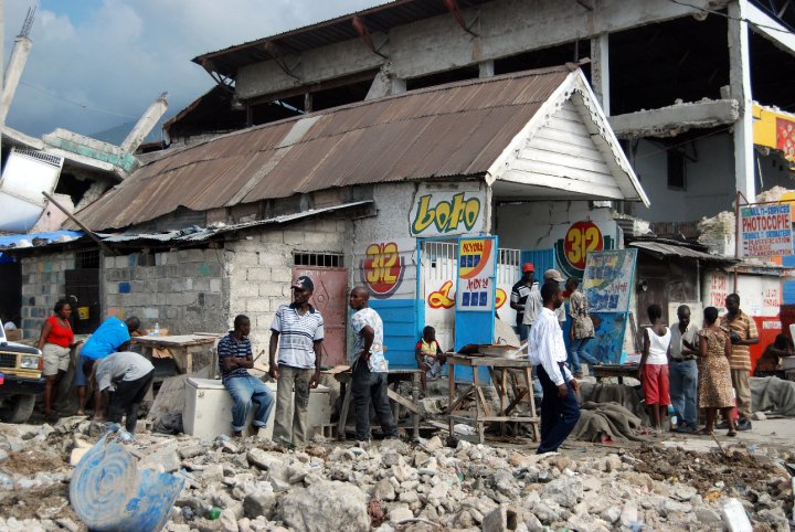 Photograph from Port-au-Prince, Haiti in 2010 after the earthquake. People outside of a makeshift shop surrounded by rubble.